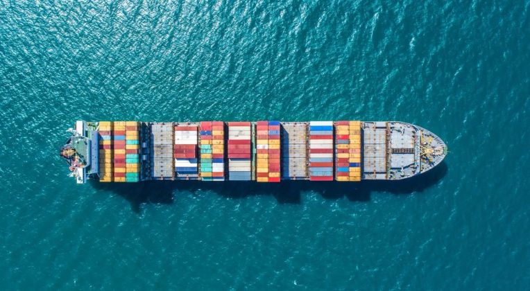 Container Freight on the Open Sea Aerial view of a container ship with colorful containers sailing through deep blue water.
